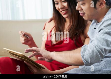 Cropped image of cheerful young couple using credit card when making purchases via application on tablet computer Stock Photo