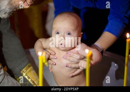 Orthodox baptism of a child. Church rite of acceptance of faith. The child is bathed at baptism. Stock Photo