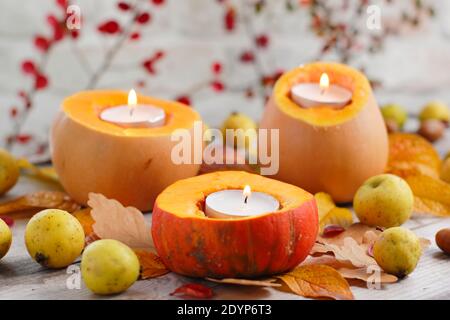 Autumn garden candles. Autumn arrangement of small pumpkins carved to hold tealight candles for a decorative garden display. UK Stock Photo