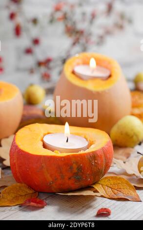 Autumn garden candles. Autumn arrangement of small pumpkins carved to hold tealight candles for a decorative garden display. UK Stock Photo