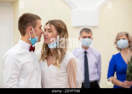 .Bride and groom wearing medical masks. Wedding during the coronavirus panademia. Marriage during the Stock Photo
