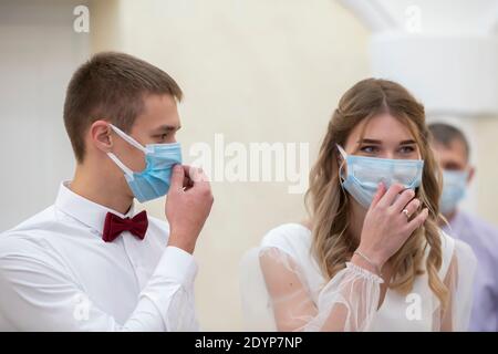 Bride and groom wearing medical masks. Getting married during the coronavirus pandemic. Stock Photo