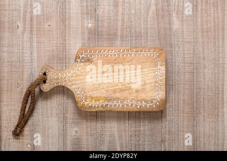 Wooden cutting board with copy space on a vintage table background. Top view. Stock Photo