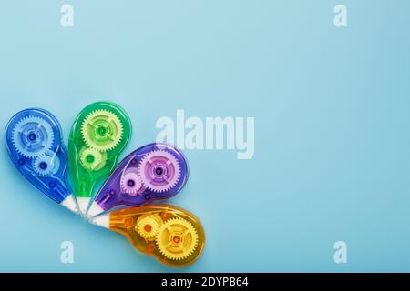 Stationery correction tapes are Multicolored on a blue background. Free space. The view from the top. Blue, green, yellow, lilac Stock Photo