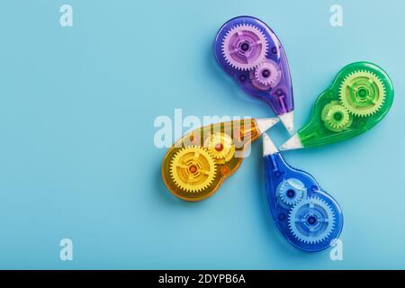 Stationery correction tapes are Multicolored on a blue background. Free space. The view from the top. Blue, green, yellow, lilac Stock Photo