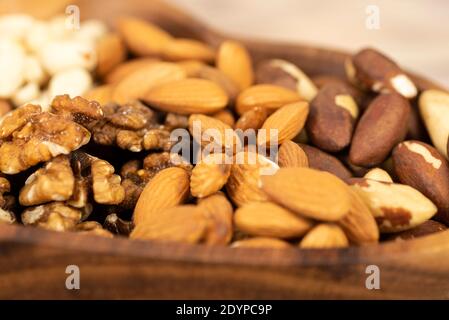 mixture of nuts in a wooden plate close-up. Stock Photo
