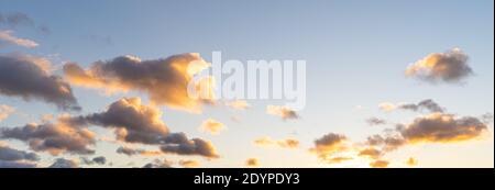 Cumulus sunset clouds with sun setting down Stock Photo