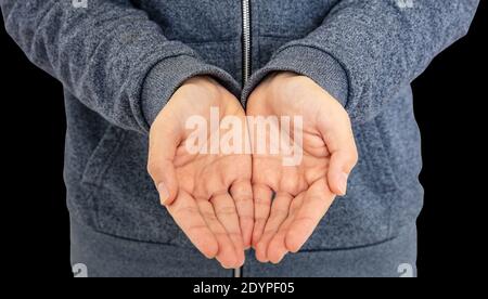 Man offering empty cupped hands isolated on black background. Male hands showing presenting concept or giving taking template Stock Photo