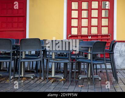 Restaurant cafe tables and seats tied with metal string in front of closed and locked shop, COVID 19 Pandemic lockdown. Empty streets, closed stores, Stock Photo