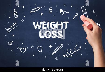 Hand drawing WEIGHT LOSS inscription with white chalk on blackboard, medical concept Stock Photo