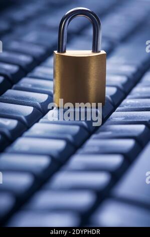 Locked metal padlock on blue computer keyboard. Data and password protection, internet and network security concept. Stock Photo