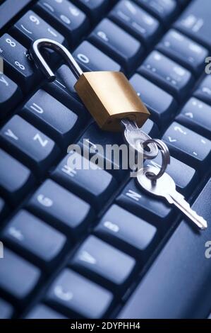 Unlocked metal padlock with keys on blue computer keyboard. Data and password protection, internet and network security concept. Stock Photo