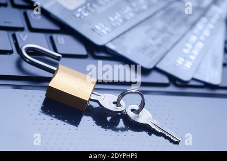 Unlocked padlock, keys and four credit cards on blue computer keyboard. E-commerce data and ebanking protection, internet and finance security concept Stock Photo