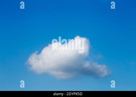 A white cloud with a blue sky in the background. Stock Photo