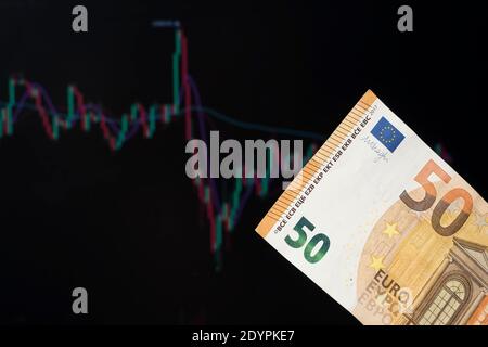 European banks and loans in Euros. 50 Euros on the background of a laptop with an open chart or diagram of the foreign exchange market or stock exchan Stock Photo
