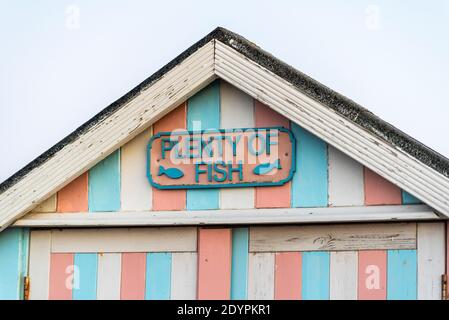 Plenty of Fish, named beach hut in Southend on Sea, Essex, UK. Pastel striped wooden hut. Brexit concept Stock Photo