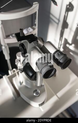 Oculars with lens of ophthalmological diagnostic equipment on doctor workplace inside medical office of contemporary ophthalmic clinics Stock Photo