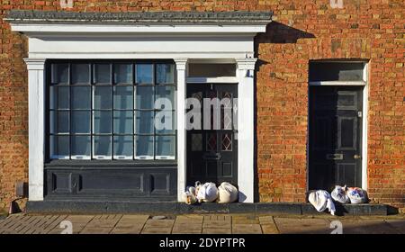 Old shop building with sandbags in doorways to prevent  flooding Stock Photo