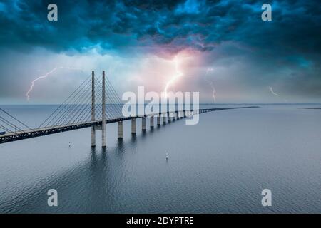 A mesmerizing aerial view of the bridge between Denmark and Sweden under the sky with lightning Stock Photo