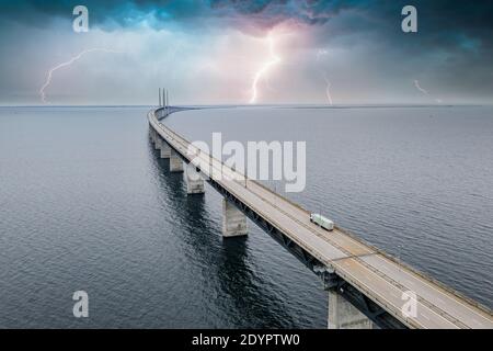 A mesmerizing aerial view of the bridge between Denmark and Sweden under the sky with lightning Stock Photo