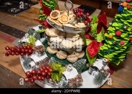 A plate of delicious tray of Christmas sweet mince fruit pies on a wooden restaurant work top Stock Photo