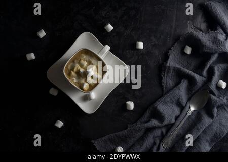 Cup of coffee and marshmallows on black background. Stock Photo