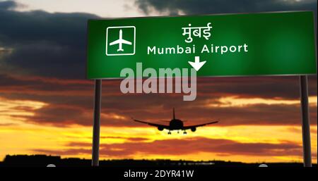 Airplane silhouette landing in Mumbai, Bombay, India, Maharashtra. City arrival with airport direction signboard and sunset in background. Trip and tr Stock Photo