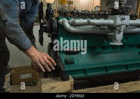 Car mechanic repairing an engine. Mechanic working on car engine. Mechanic workshop. Stock Photo