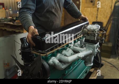 Car mechanic repairing an engine. Mechanic working on car engine. Mechanic workshop. Stock Photo