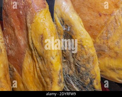 Whole legs of cured Spanish Iberian serrano ham (Jamon Serrano) hanging in a store Stock Photo