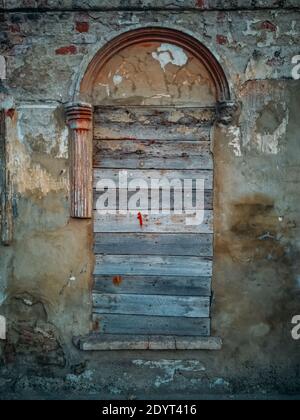 Wall of abandoned building with broken boarded up windows. Stock Photo