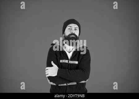 Warm and comfortable. Fashion menswear shop. Masculine clothes concept. Think and decide. Winter menswear. Man bearded warm jumper and hat red background. Winter season menswear. Personal stylist. Stock Photo