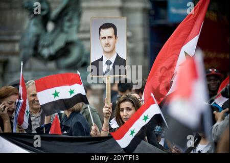 Demonstrators raise portraits of Syrian President Bashar al-Assad in Paris, France, on September 8, 2013, to protest against a potential military strike against Syria. Syrian President Bashar al-Assad has denied in an interview with CBS television that he was behind a chemical attack last month and called on lawmakers to reject planned US military strikes, the US network said on September 8. Photo by Nicolas Messyasz/ABACAPRESS.COM Stock Photo