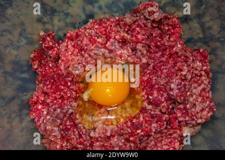 Egg on raw ground beef in close-up Stock Photo