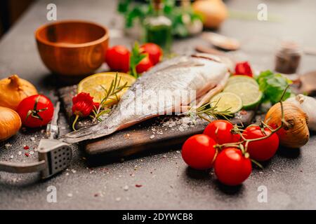 Preparing fresh gilthead sea bream.Local fish market.Fresh seafood and vegetables.Expensive dorado fish recipe and seasoning.Healthy Mediterranean die Stock Photo