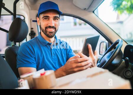 Delivery man driver using digital tablet. Stock Photo