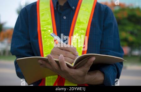 Engineer write take note on book for planing work Stock Photo