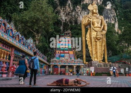 Batu Caves, Malaysia. 27th Dec, 2020. A Hindu devotee seen in front of the colourful steep 272-step stairs and the gigantic Lord Murugan golden statue at Batu Caves.Malaysia has estimated to have lost more than RM100 billion on tourism sector this year due to the coronavirus pandemic. Prime Minister Muhyiddin Yassin said the global pandemic has crippled the tourism industry, which had contributed 15.9 percent or RM240.2 billion of Malaysia gross domestic product in 2019. Credit: SOPA Images Limited/Alamy Live News Stock Photo