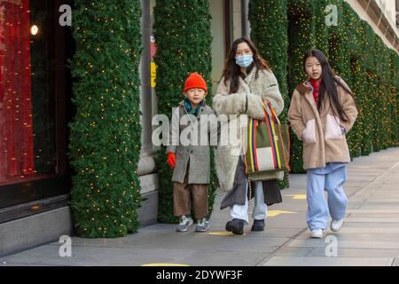 London, UK. 27th Dec, 2020. Shoppers walk past Christmas decorations in New Bon Street.Under tier four restrictions, pubs and restaurants will close, as well as ‘non-essential' retail. Credit: SOPA Images Limited/Alamy Live News Stock Photo