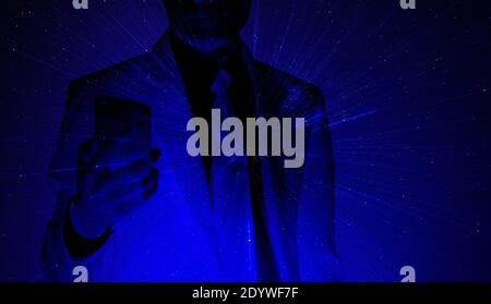 Business man holding mobile smart phone on dark blue background AI Artificial intelligence technology Stock Photo