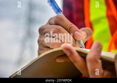 Engineer writing on notebook at work Stock Photo