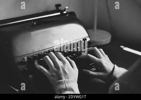 Hand typing typewriter on wooden table Stock Photo