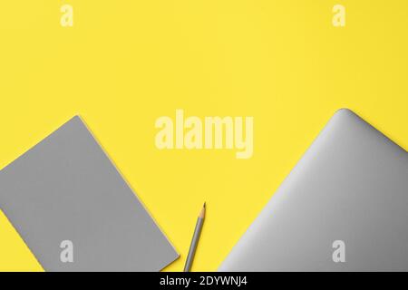 Laptop, notepad and pencil on yellow background Stock Photo