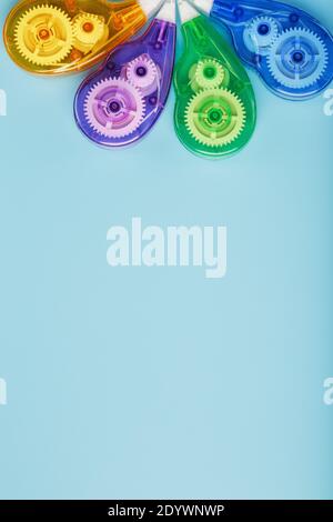 Multi-colored Stationery correction tapes on a blue background. Free space. The view from the top Stock Photo