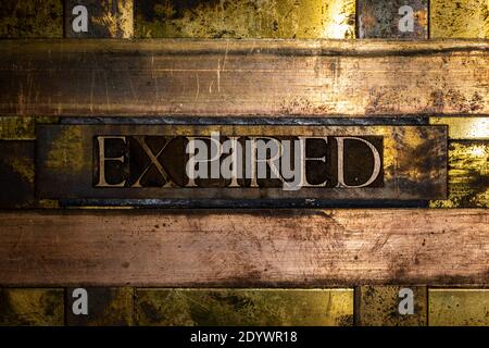 Expired text on vintage grunge textured copper and gold background Stock Photo