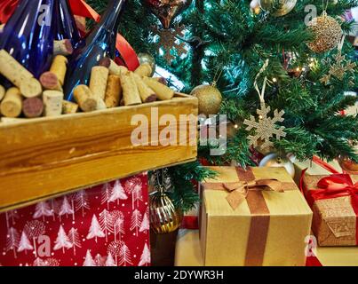 Christmas tree decorated with toys, New Year's gifts under the tree and wine. New Year concept Stock Photo