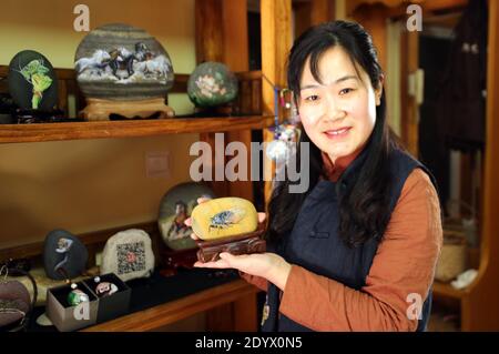 December 28, 2020, Yantai, Yantai, China: Shandong,CHINA-A fishing girl from Yantai city, Shandong Province, who has loved painting since childhood, started to create stone paintings on her collection of Ball stones on Changdao Island in 2017...A picture of animals, landscape paintings and other show on the stone, small and lovely, lifelike...Many friends came to order. (Credit Image: © SIPA Asia via ZUMA Wire) Stock Photo