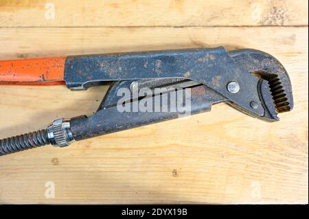 open pipe wrench lying on wooden workingbench Stock Photo