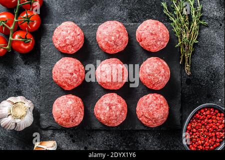 Raw meatballs, minced pork meat. Black background. Top view Stock Photo