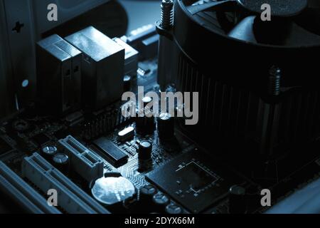 Components on PC circuit board. Chip, fan, capacitor and connectors on the motherboard of a personal computer. Inside photo for background. Stock Photo